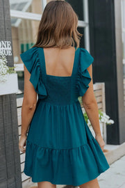 the back of a woman wearing a teal dress