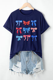 a t - shirt with bows is hanging on a hanger