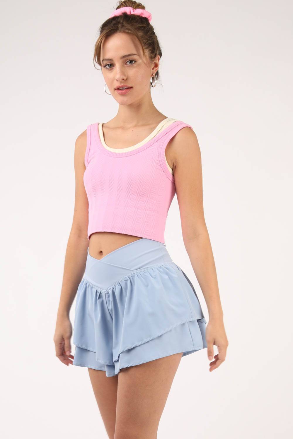 a woman in a pink top and blue skirt