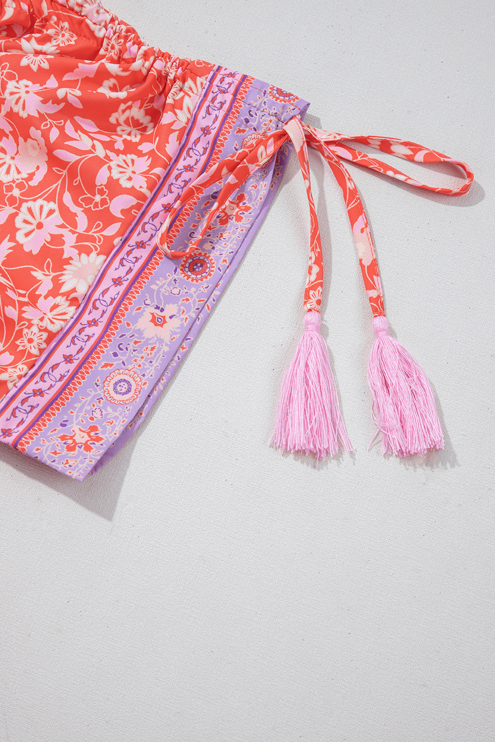 tasseled sleeve tie detail on Red Floral Print Tasseled Tied Sleeve Empire Waist Maxi Dress, enhancing its boho-chic appeal