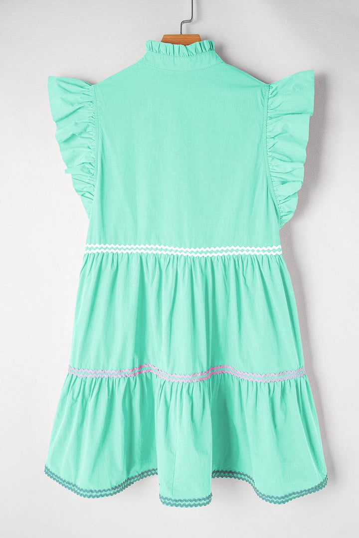 a little girl's green dress hanging on a wall