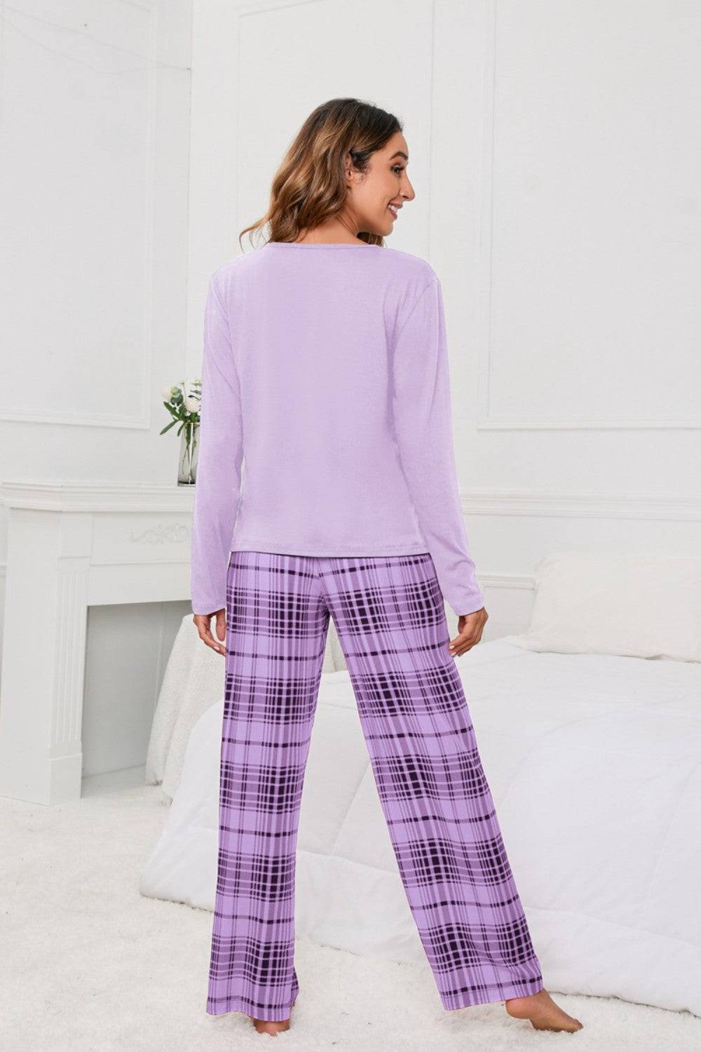 a woman wearing a purple top and plaid pants