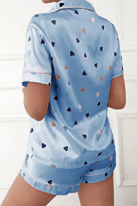 a woman wearing a blue pajama set with hearts on it