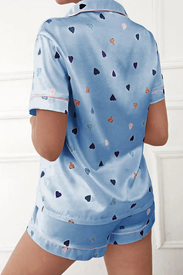 a woman wearing a blue pajama set with hearts on it