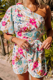 a woman wearing a floral print rom with a tie around the waist