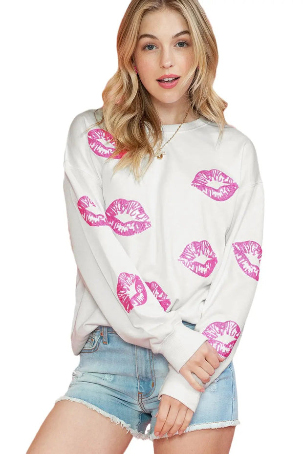 a woman wearing a white sweater with pink lips on it
