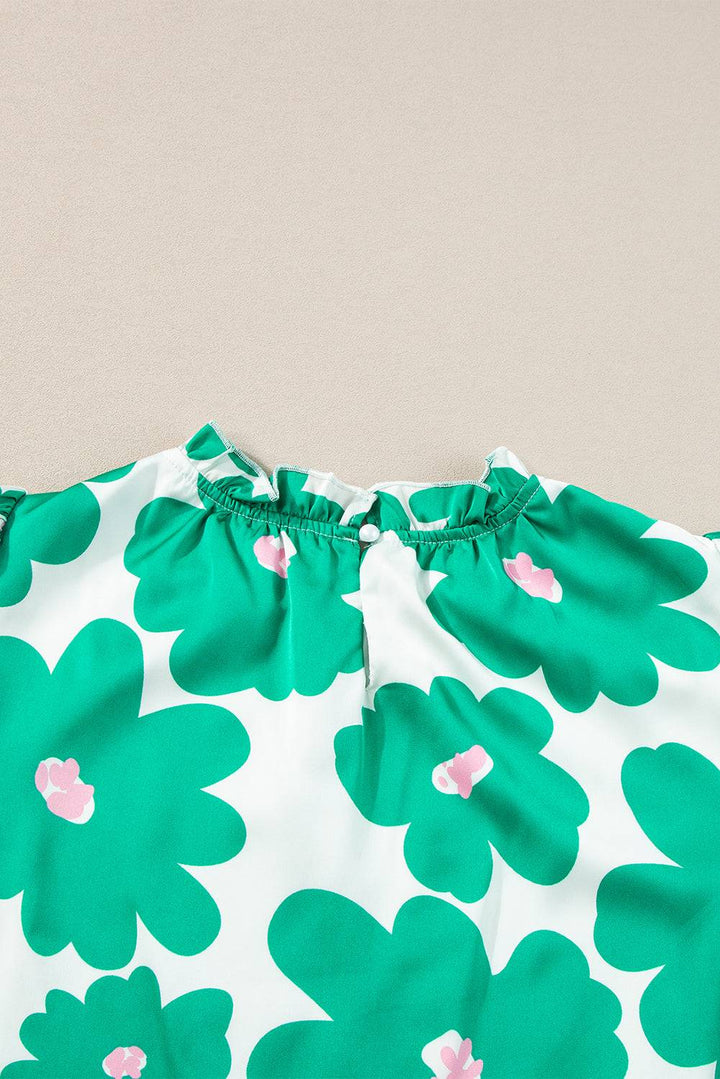 a close up of a green and white flowered dress