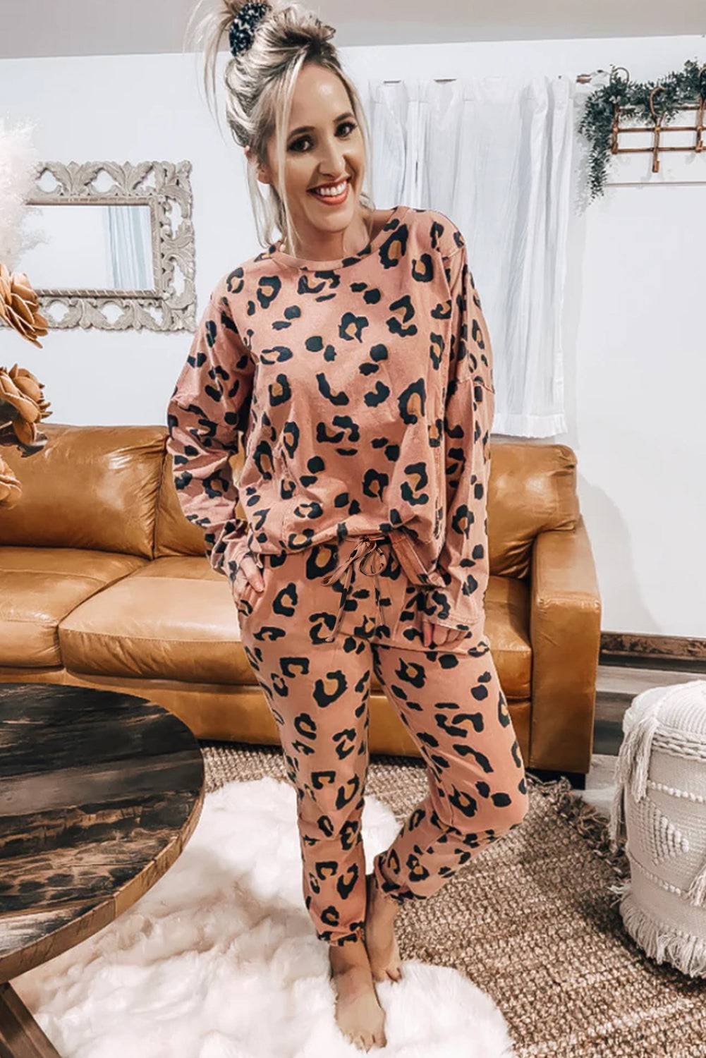 a woman standing in a living room wearing leopard print pajamas