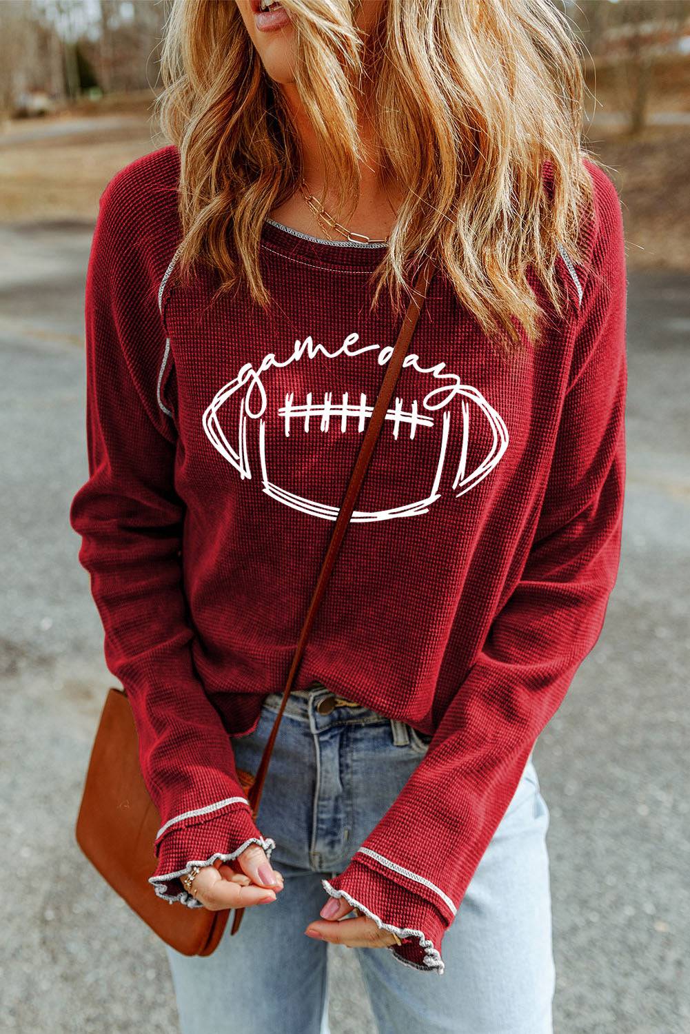 a woman wearing a red sweater with a football drawn on it