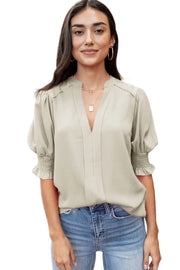 a woman in jeans and a blouse posing for a picture