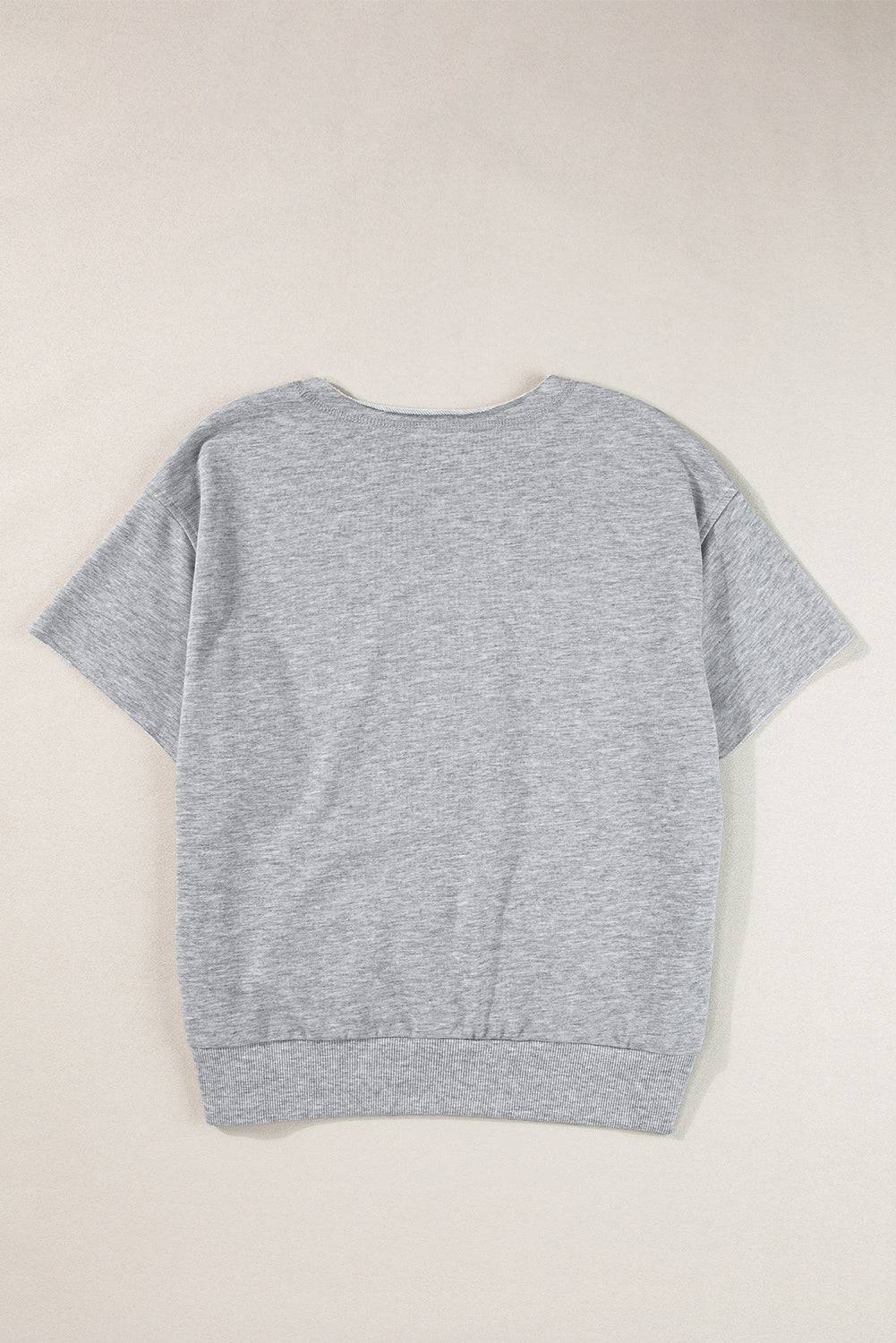 a grey sweater hanging on a white wall