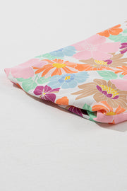 a pink and blue flowered cloth laying on top of a white surface