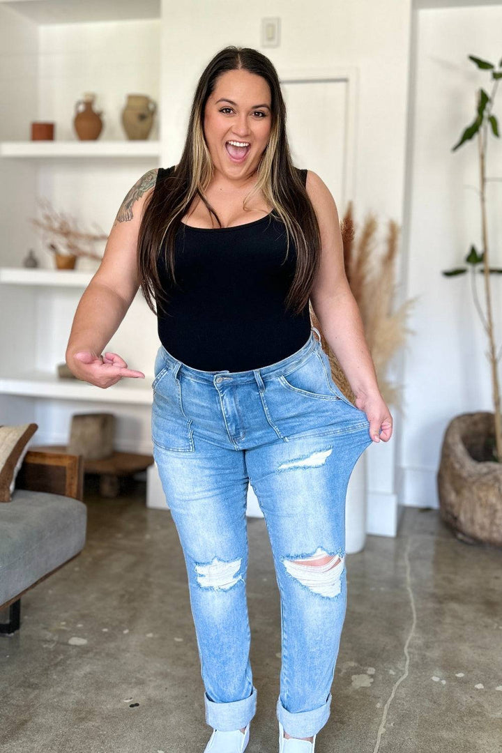 a woman in a black tank top and ripped jeans