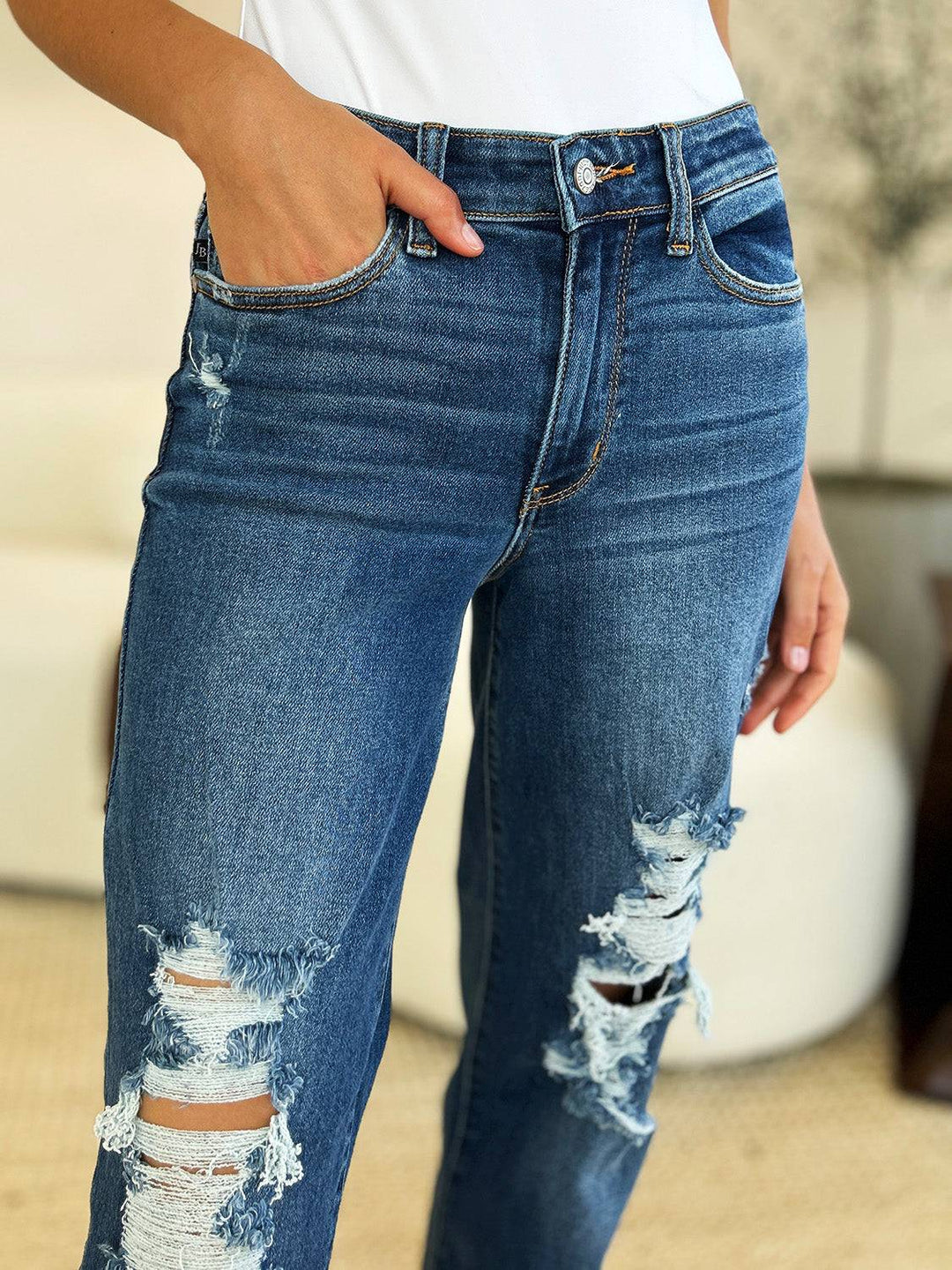 a woman wearing ripped jeans and a white shirt