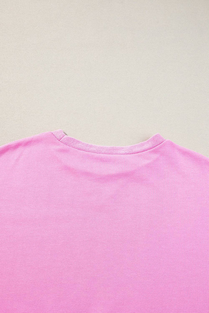a close up of a pink shirt on a white surface