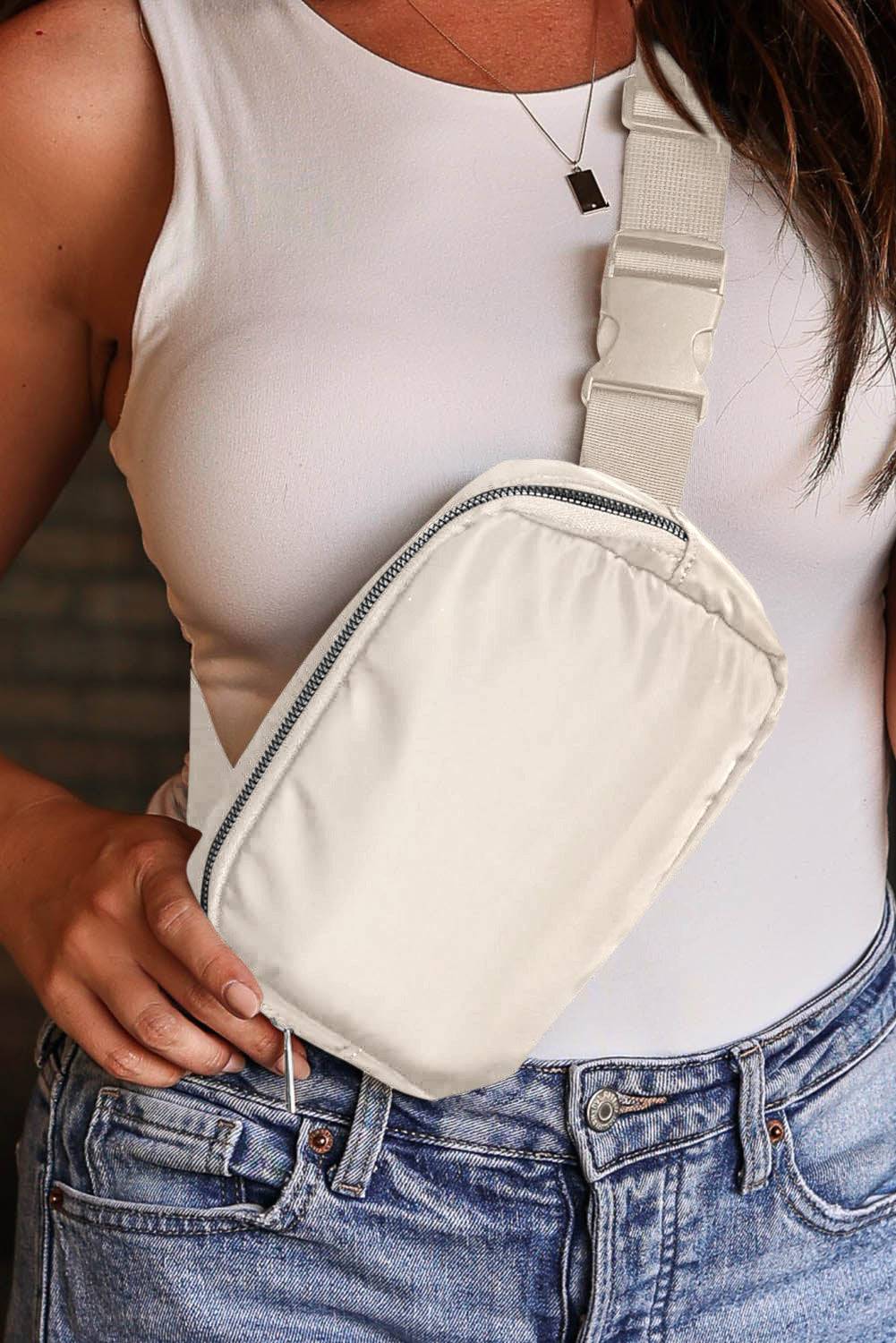 a woman in a white tank top is holding a white fanny bag