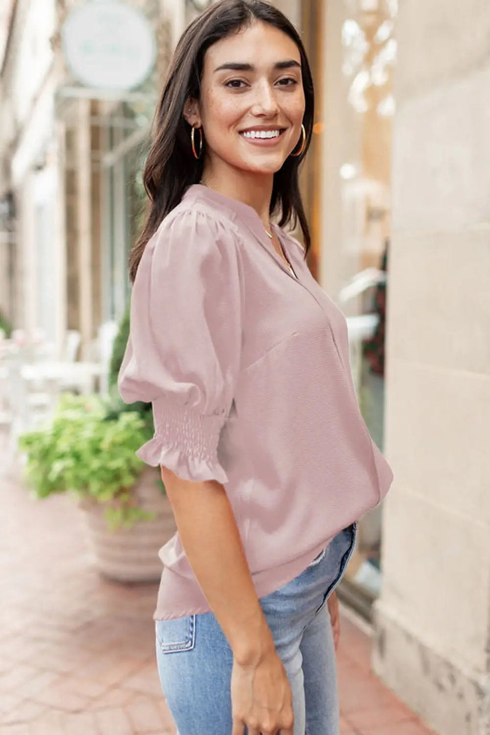 a woman standing on a sidewalk with a handbag