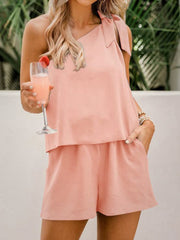 a woman holding a drink and wearing a pink top