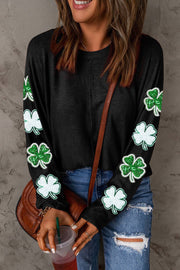 a woman holding a cup of coffee wearing a st patrick's day sweater