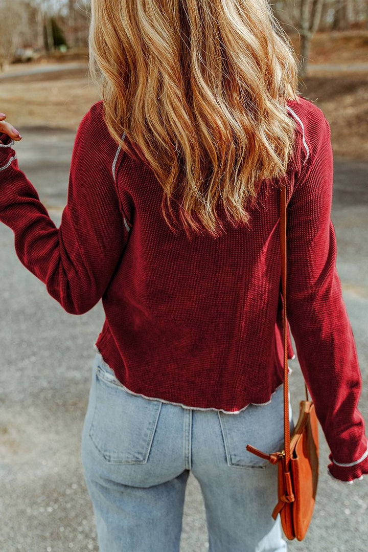 a woman in a red sweater is holding a cell phone