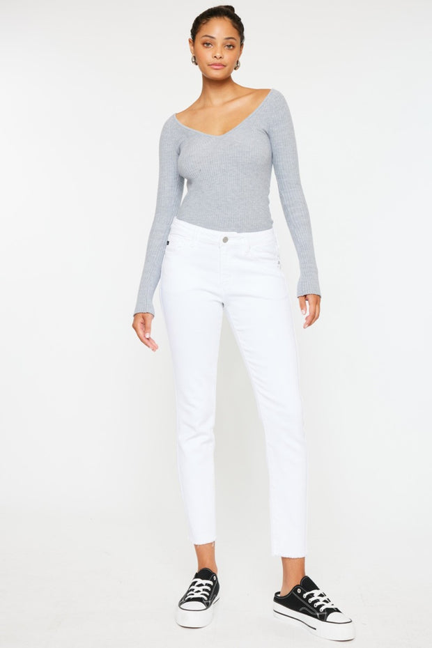 a woman in a grey sweater and white pants