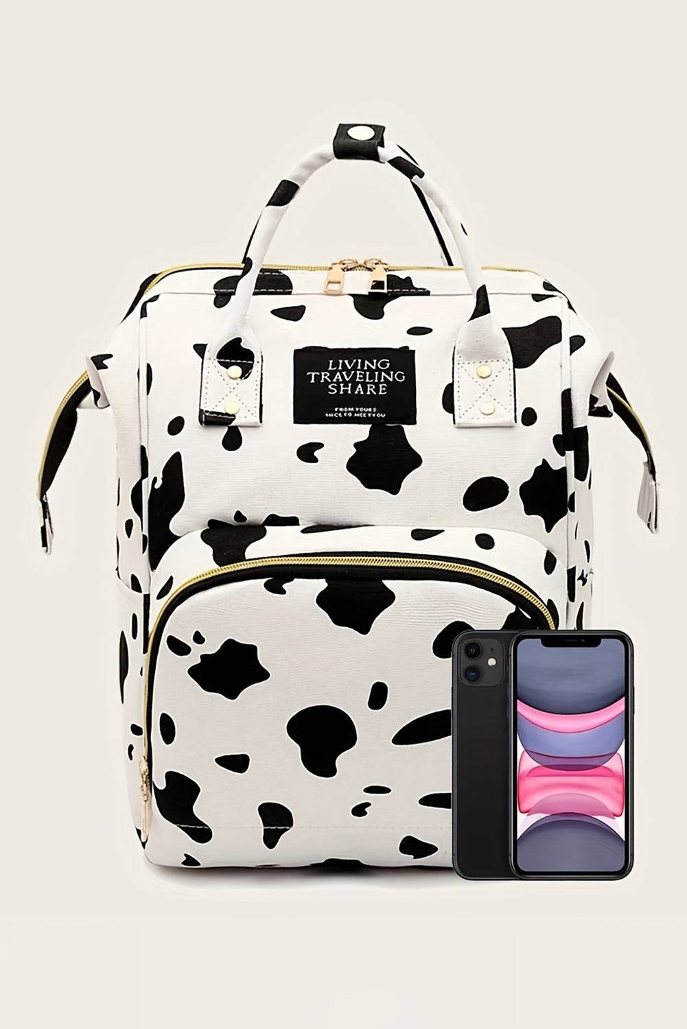 a black and white cow print backpack and a cell phone