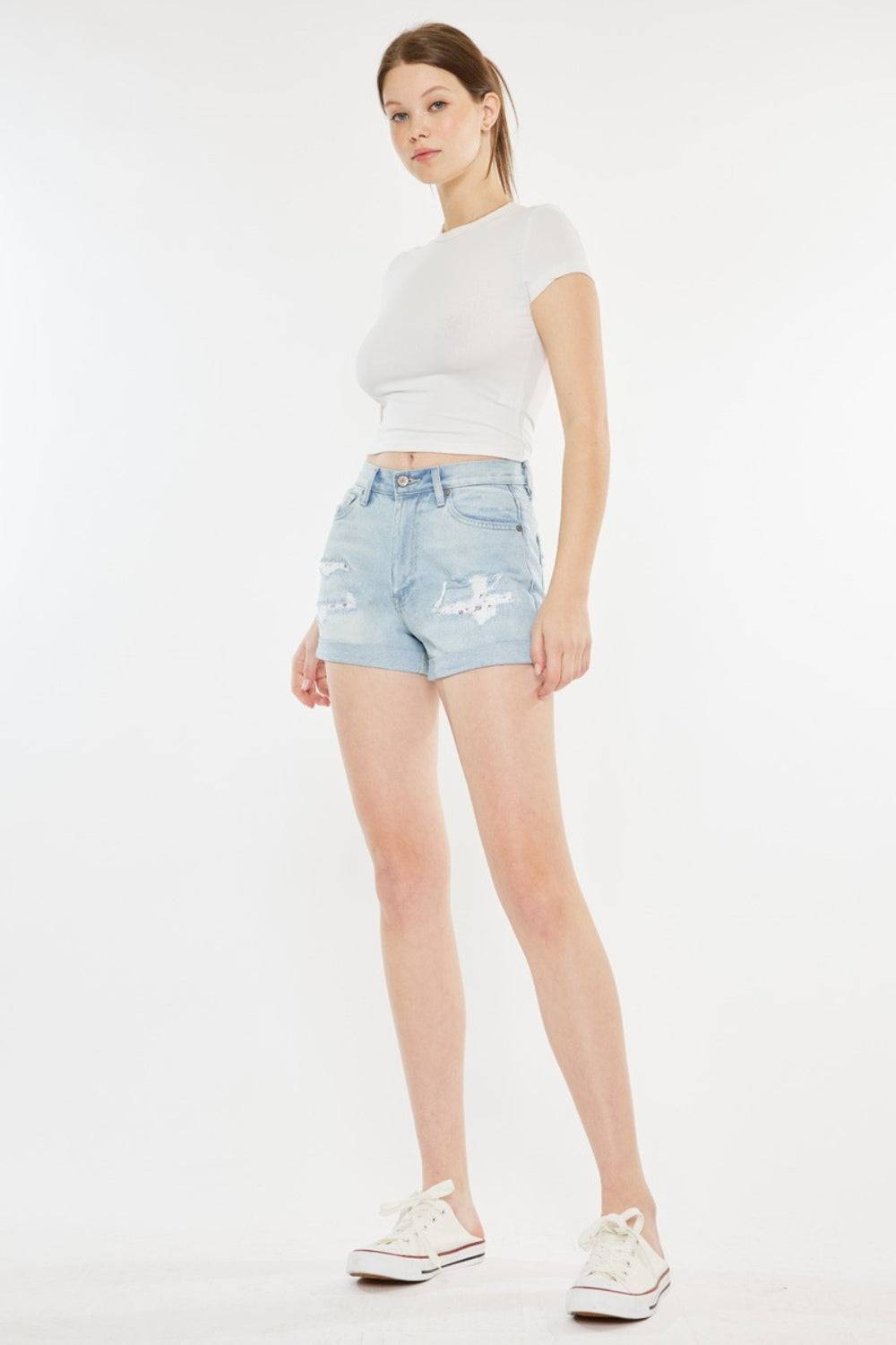 a woman in white shirt and shorts posing for a picture