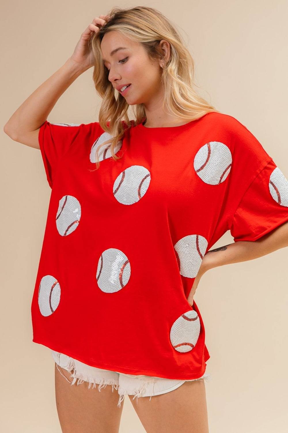 a woman wearing a red shirt with white polka dots on it