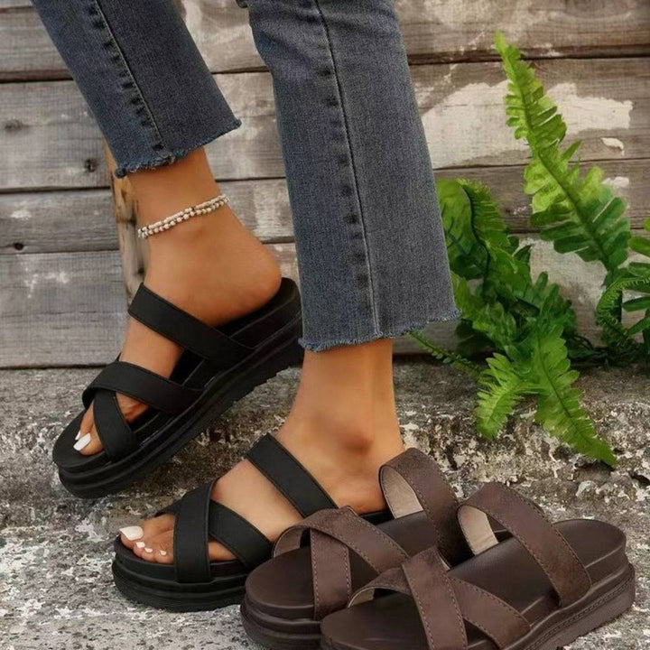 a woman wearing a pair of brown sandals