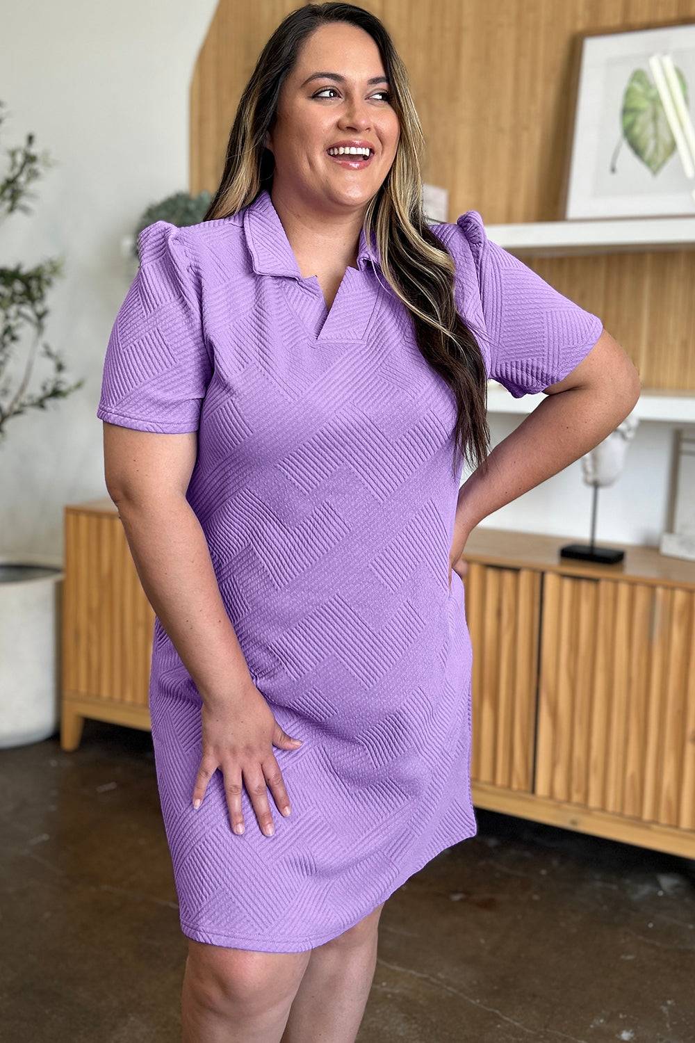 a woman in a purple dress posing for a picture