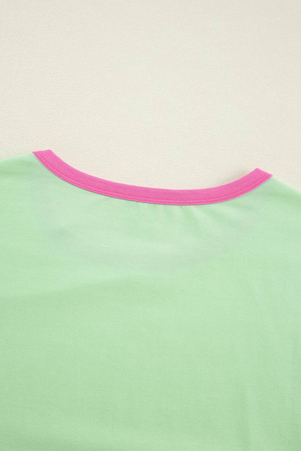 a woman's green shirt with pink trim