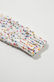 a piece of white cloth with multicolored dots on it