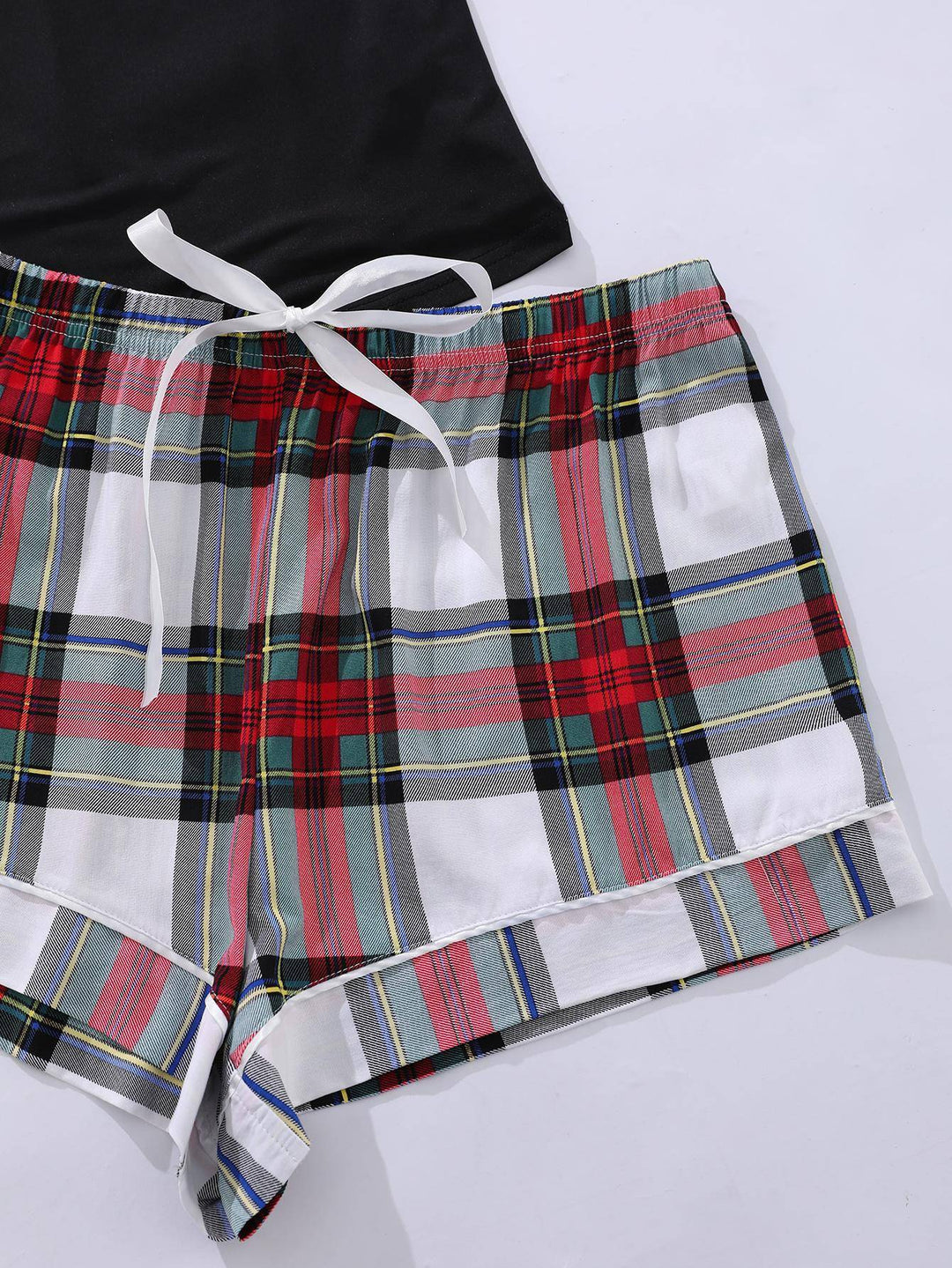 a pair of plaid shorts with a black tank top