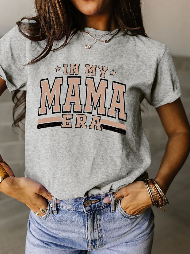 a woman wearing a gray shirt that says in my mama era