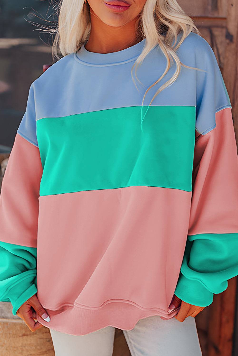 a woman wearing a pink, blue, and green sweatshirt