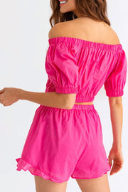 a woman wearing a pink romper and shorts