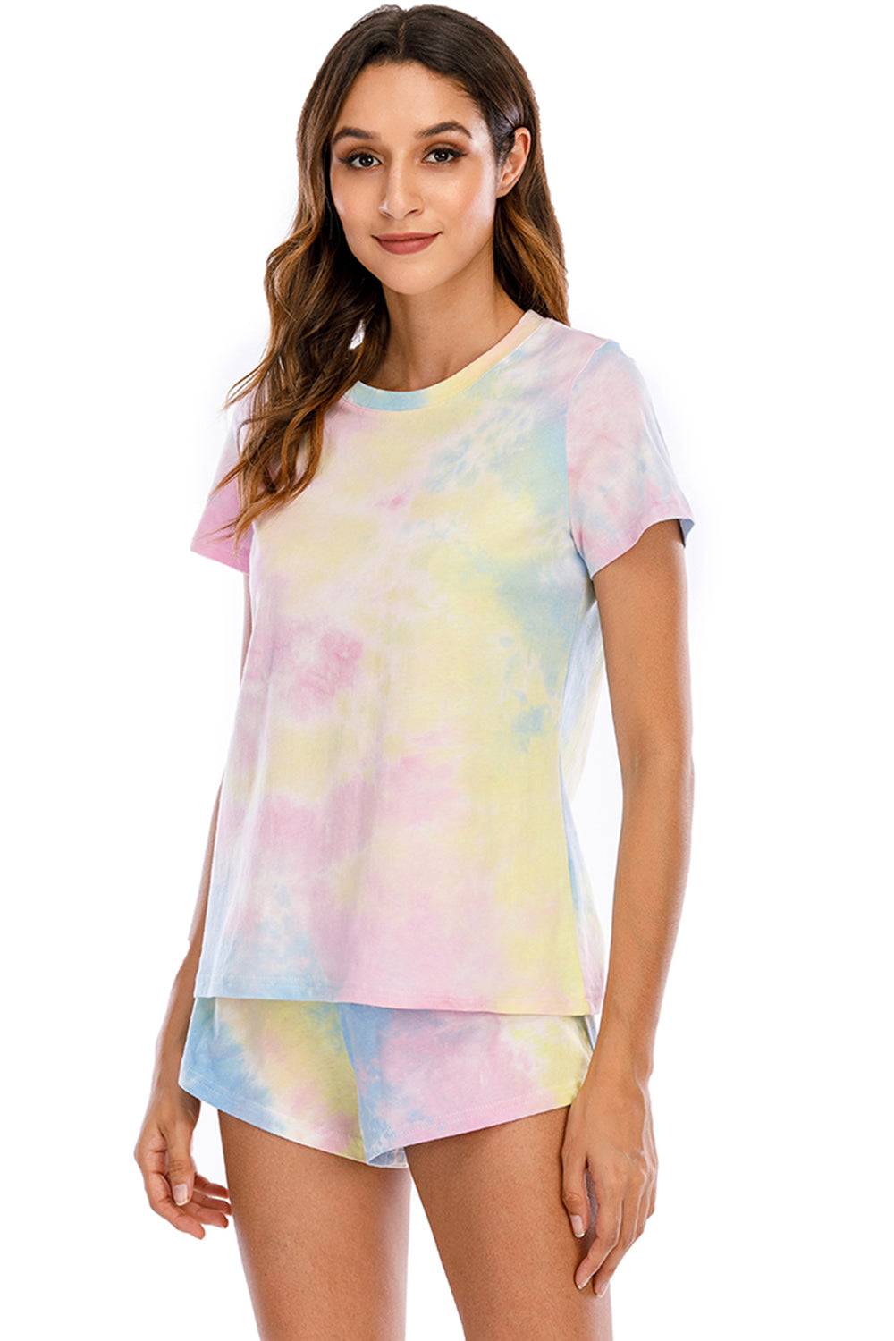 a woman wearing a tie dye shirt and shorts