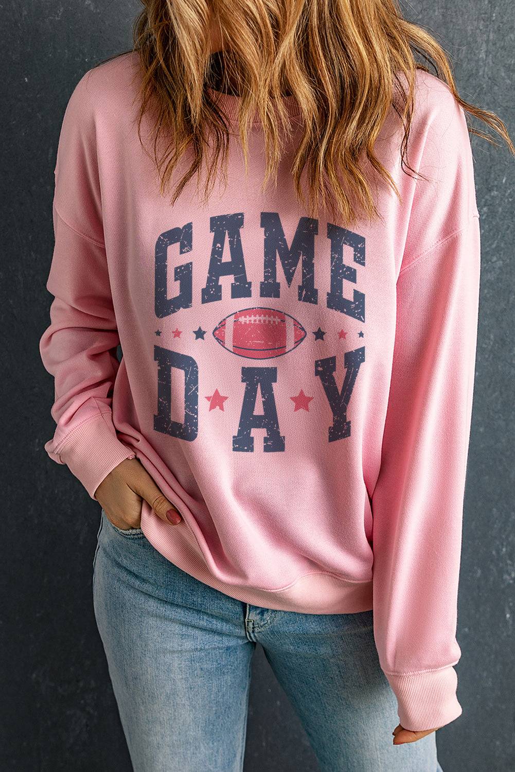 a woman wearing a pink game day sweatshirt