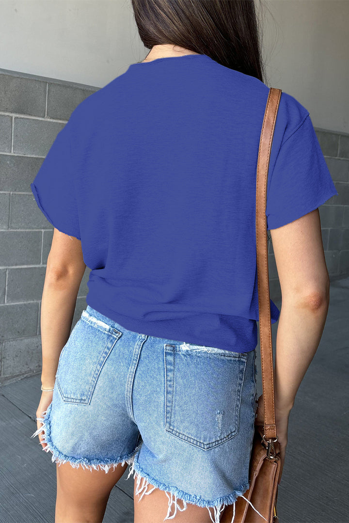 a woman wearing a blue shirt and denim shorts