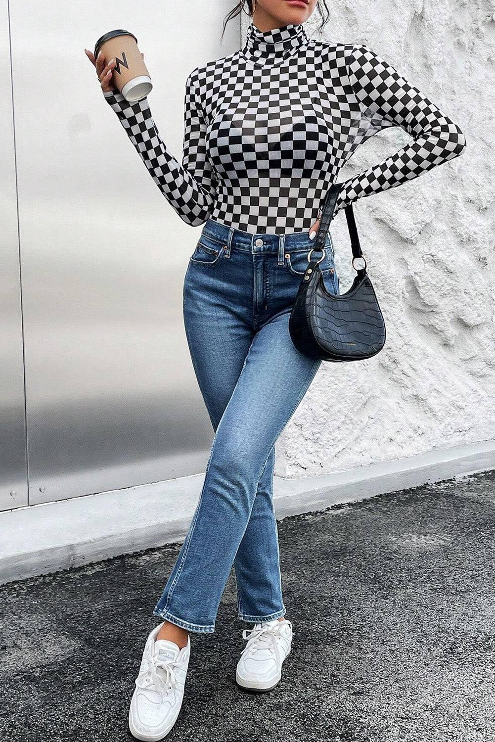 a woman in a black and white checkered shirt and jeans