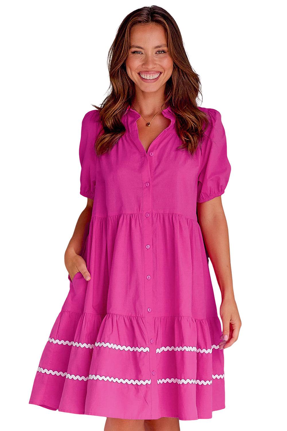 a woman in a pink dress smiling at the camera
