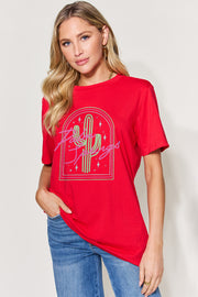a woman wearing a red shirt with a cactus on it