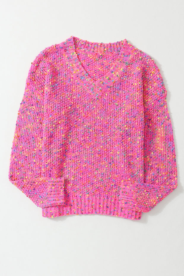 a pink sweater with multicolored speckles on it