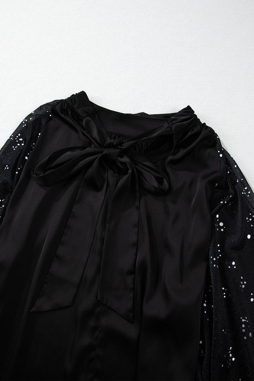 a black blouse with a bow at the neck