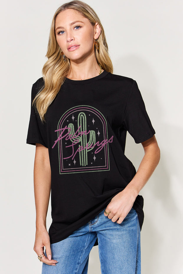a woman wearing a black t - shirt with a cactus on it