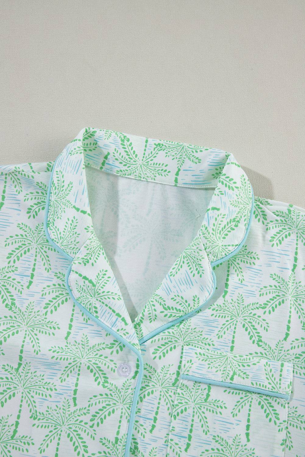 a white shirt with green leaves on it