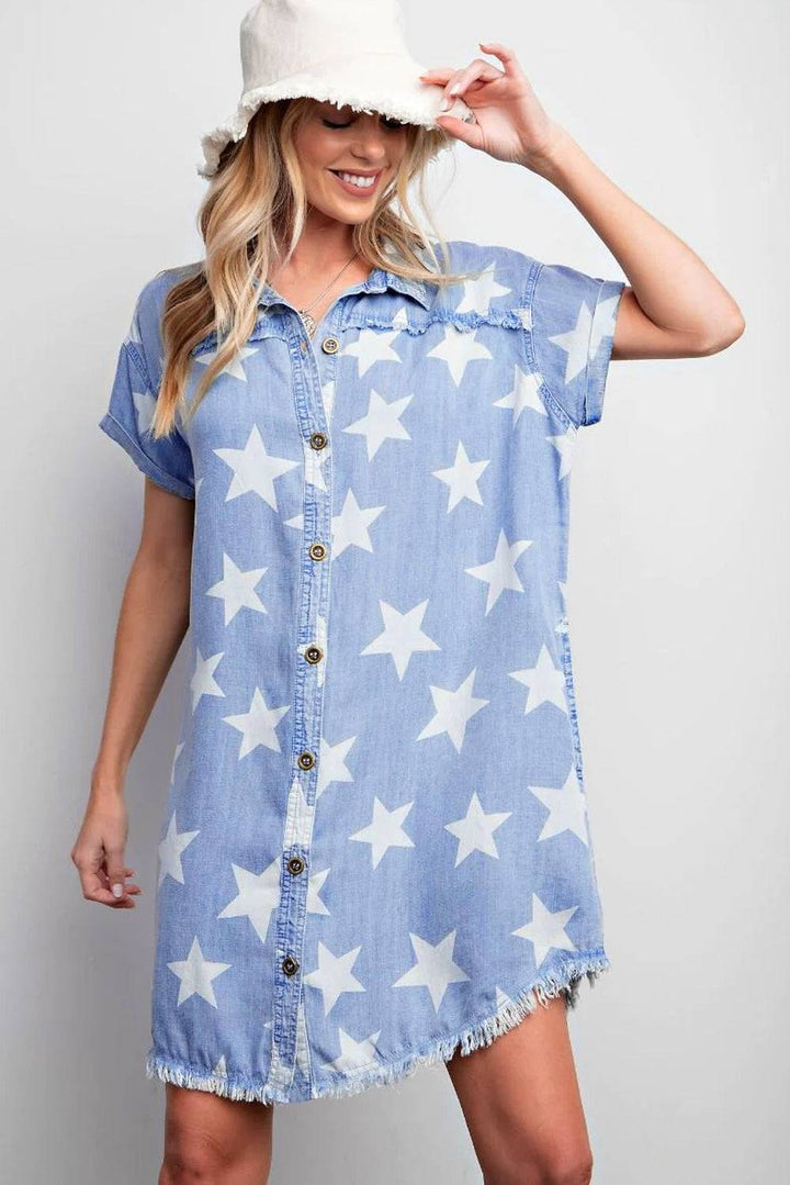 a woman wearing a denim shirt dress with white stars on it