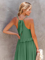 a woman in a green dress is holding a purse