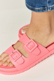 a close up of a person wearing pink sandals
