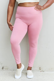 a woman in a white top and pink leggings